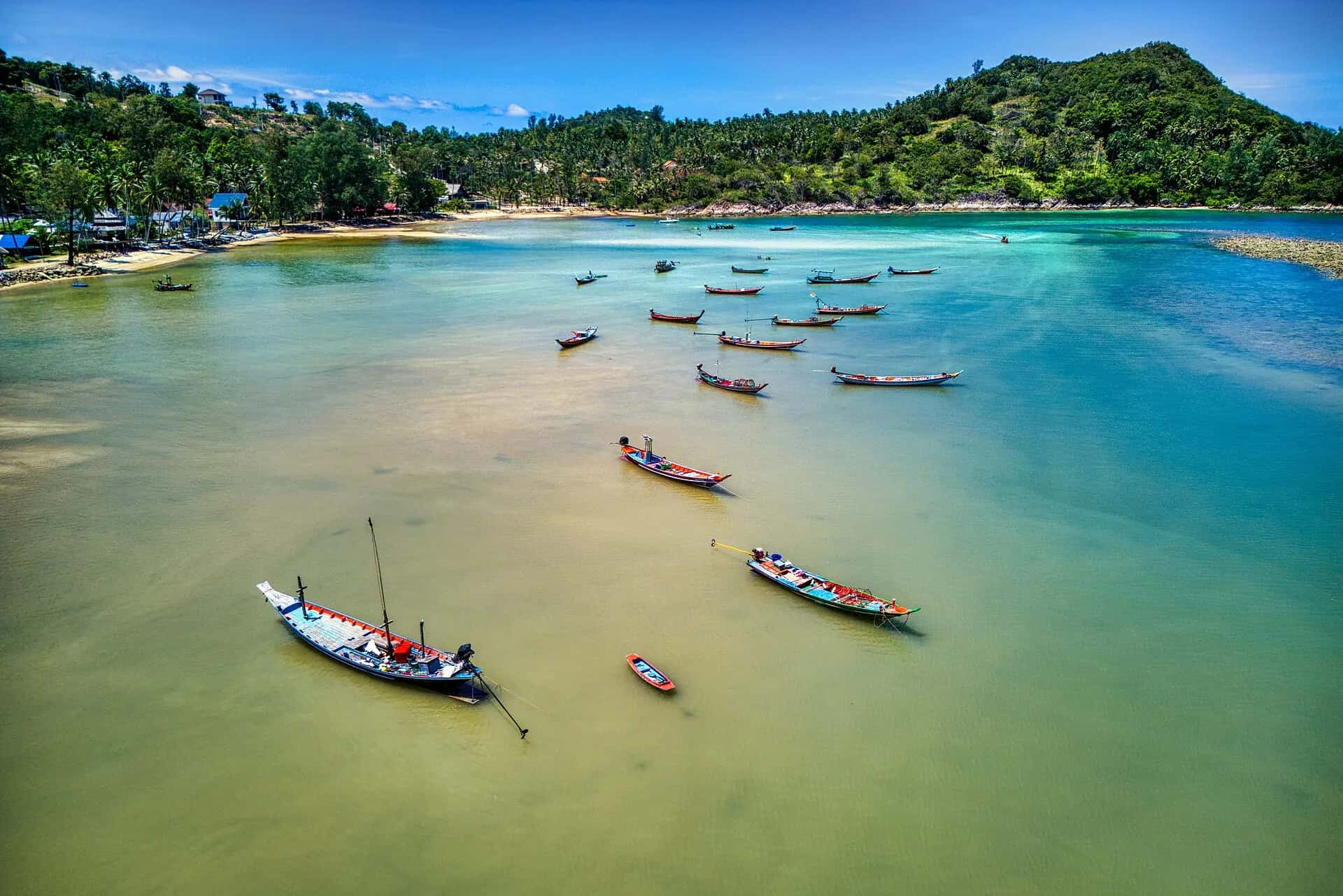 Aerial view of longtail boats moored in the shallow turquoise bay of Chalok Lam
