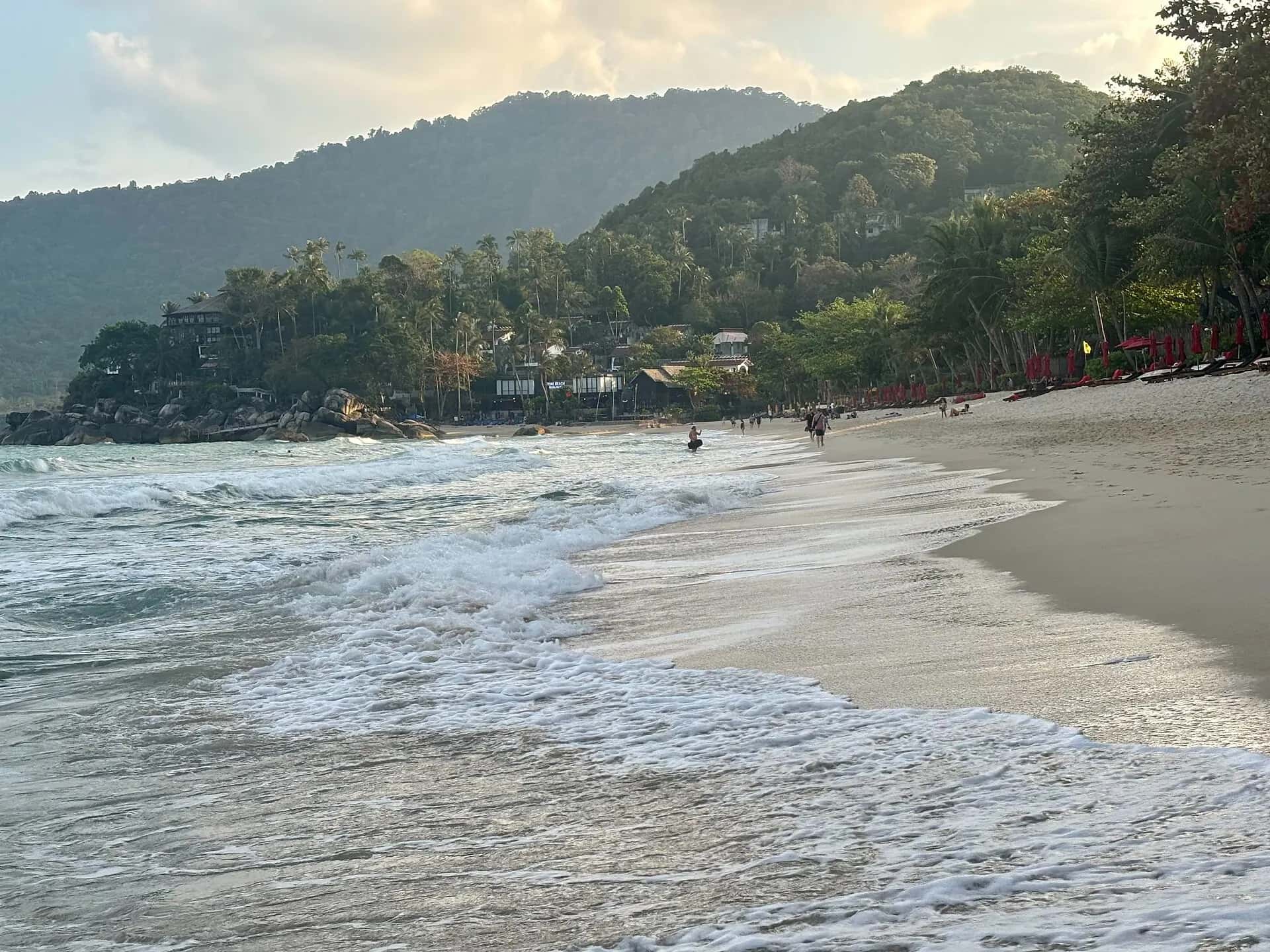 Waves rolling onto the beach at Thong Nai Pan, with forested hills behind